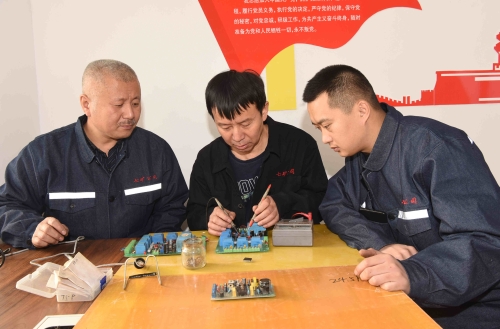 000   七矿公司新兴矿王守朋工作室坚持技术创新，科技创效，成效显著。图为王守朋（中）与科研小组在一起专研业务。孙国祥摄_副本